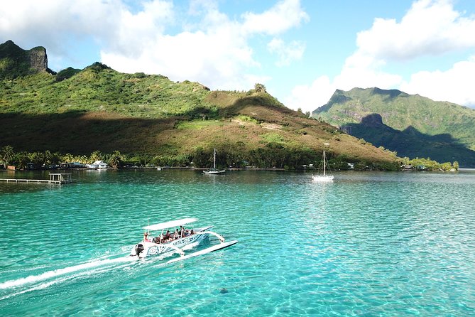 A boat crossing the shallow turquoise lagoon off Moorea